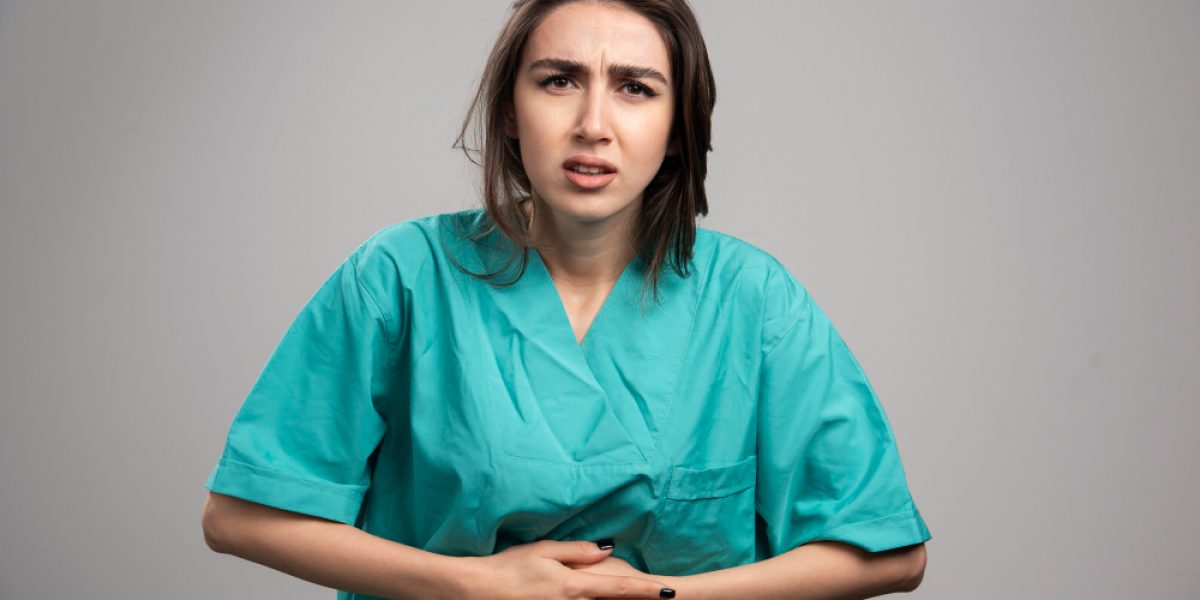 female-doctor-having-stomach-ache-gray-background-high-quality-photo