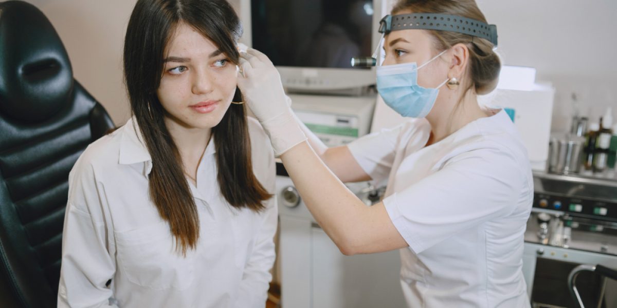woman-patient-medical-office-doctor-medical-mask-lor-checks-woman-ears (1)
